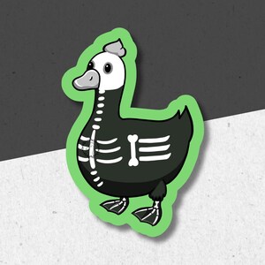May include: A green sticker with a black and white cartoon duck wearing a skeleton costume. The duck has a white head and a black body with white bones.