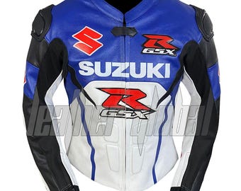 May include: Blue, white, and black leather motorcycle jacket with Suzuki and GSX logos. The jacket features a stand-up collar, padded shoulders, and zippered cuffs. The design includes white and black accents on the sleeves and front.