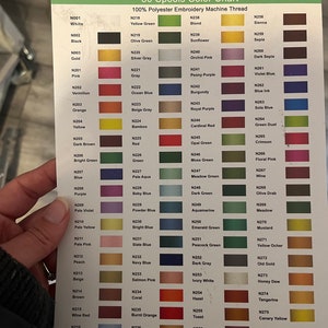 May include: A color chart with 80 spools of 100% polyester embroidery machine thread. The chart is organized by color family and includes a variety of shades, from white to black, and from bright to muted.
