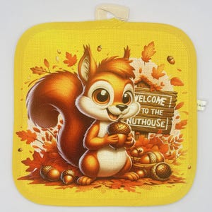 May include: Yellow kitchen pot holder with a cartoon squirrel holding an acorn. The squirrel is surrounded by autumn leaves and acorns. The sign reads "Welcome to the Nuthouse".