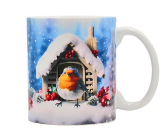 May include: A white ceramic mug with a winter scene featuring a robin perched on a snow-covered birdhouse. The background is a blue sky with falling snow.