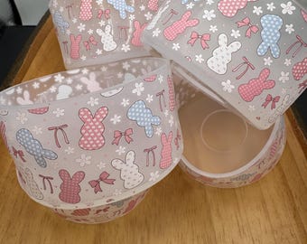 May include: Set of four clear plastic bowls with a pastel pink and blue bunny and bow pattern.