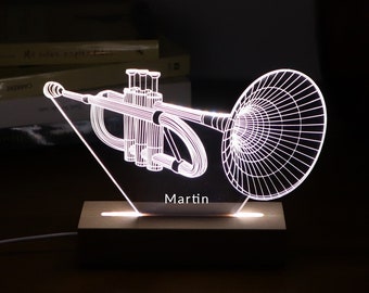 May include: A white LED night light shaped like a trumpet with the name "Martin" inscribed on the base. The light is on a wooden base.