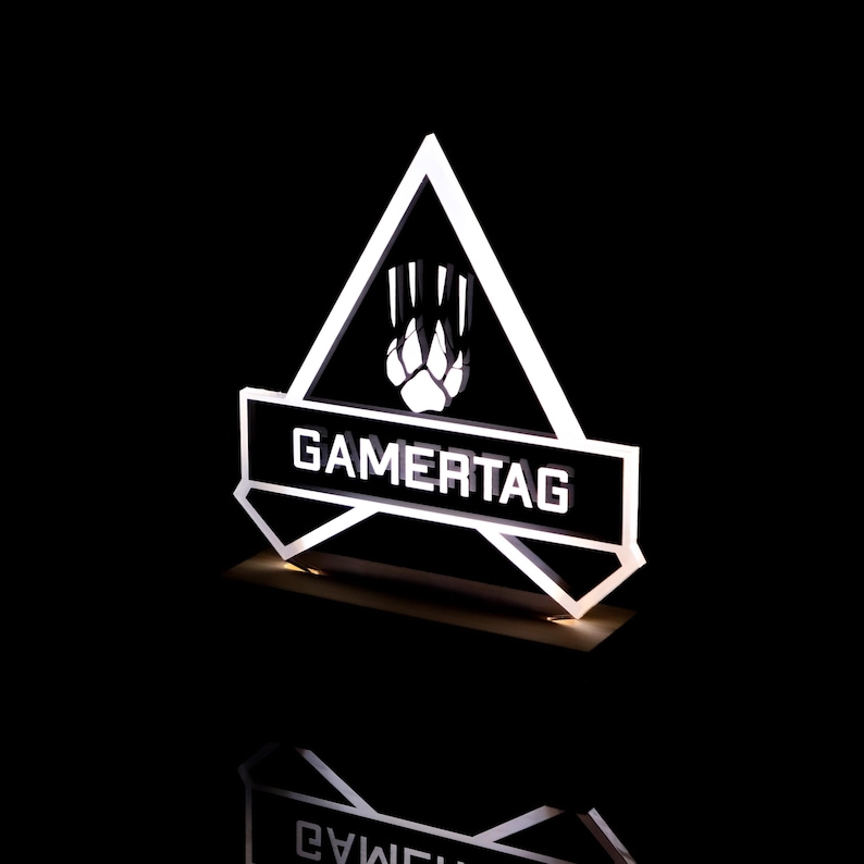 May include: A white acrylic gamertag sign with a black triangle and a paw print inside. The sign reads "GAMERTAG" in white letters.