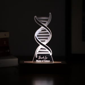 3D illusion lamp featuring a detailed DNA double helix design, illuminated in a white tone, personalized with a name, perfect as a unique and thoughtful gift for geneticists, scientists, or medical professionals specializing in human genome research