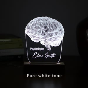 Personalized 3D illusion lamp featuring a detailed brain anatomy design, illuminated in a white tone,  perfect as a unique gift for mental health professionals.