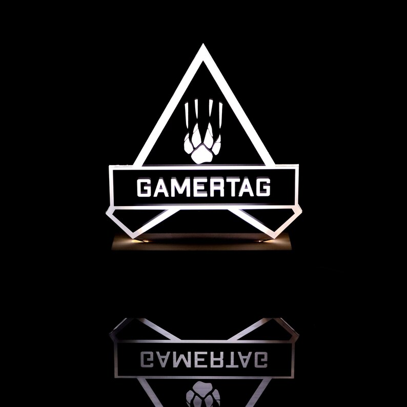 May include: A white illuminated sign with a black triangle shape. The triangle has a paw print inside and the text "GAMERTAG" on a black rectangle at the bottom.