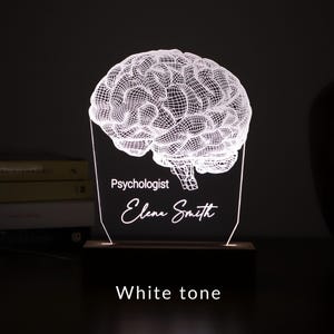 Personalized 3D illusion lamp featuring a detailed brain anatomy design, illuminated in a white tone,  perfect as a unique gift for mental health professionals.