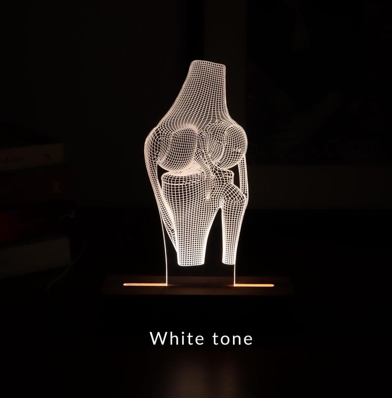 3D illusion lamp featuring a detailed human knee joint anatomy design, illuminated in a white tone, perfect as a unique and thoughtful gift for orthopedic specialists, physiotherapists, or medical professionals focusing on joint health.