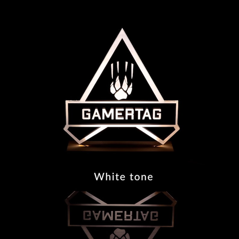 May include: A white illuminated sign with a black triangle shape and the word "GAMERTAG" in white letters. The triangle has a white paw print inside. The sign is on a black background.