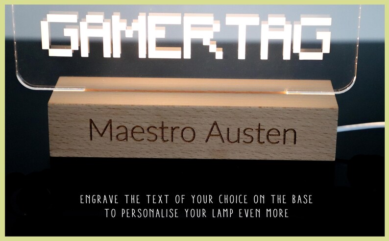 May include: A wooden base with the text "GAMERTAG" engraved on it. The base is illuminated by a clear acrylic sign with the text "GAMERTAG" in white pixelated letters. The base also has the text "Maestro Austen" engraved on it.