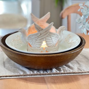 May include: A set of three ceramic mugs with a speckled, matte finish in cream, light grey, and dark grey. Each mug has a simple, minimalist design and a rounded handle.