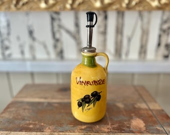 Vinagrera mediterránea con pico de acero inoxidable y aceitunas negras de color amarillo brillante