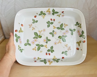 Puede incluir: Plato rectangular para hornear de cerámica blanca con borde dorado y un patrón floral de hojas verdes, flores rosas y fresas rojas.