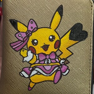 Cartera compacta de mujer de cuero dorado grabado con disfraz de Pikachu