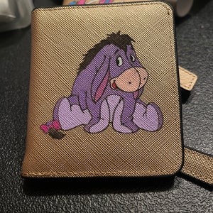 Cartera compacta para mujer de piel dorada con grabado de Eeyore
