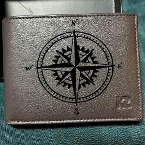 Cartera de viaje para hombre con brújula de cuero grabada, ideal para actividades al aire libre.