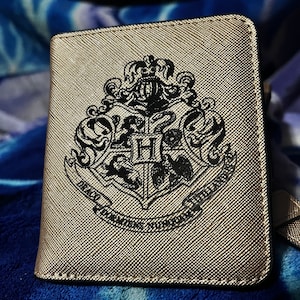 Cartera compacta de mujer en piel dorada grabada con el escudo de los Wizards
