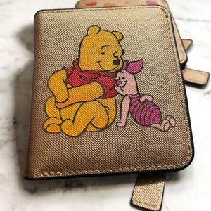 Cartera compacta de mujer en piel dorada con grabado de Winnie the Pooh