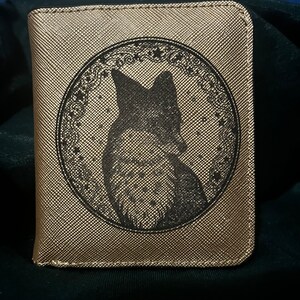 Cartera compacta para mujer de piel dorada grabada con el escudo del zorro