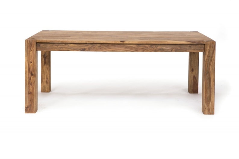 May include: A rectangular wooden dining table with a natural finish. The table has a solid, blocky design with four sturdy legs. The wood grain is visible, showcasing the natural color variations. This table is approximately 72 inches long and 36 inches wide.