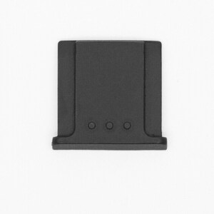 May include: Black plastic camera lens cap with four small holes.
