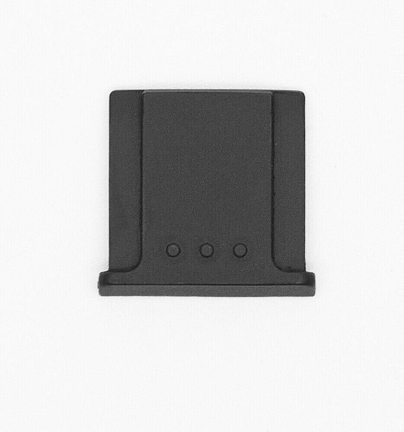 May include: Black plastic camera lens cap with four small holes.
