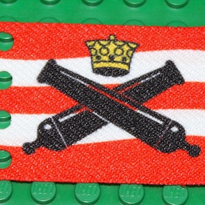 May include: A red and white striped flag with a black and white image of two crossed cannons and a gold crown on top.