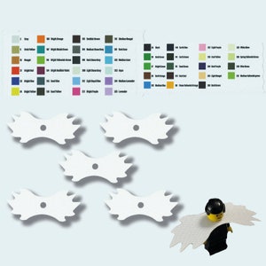 Könnte beinhalten: Fünf weiße, flügelförmige Accessoires mit einem zentralen Loch, möglicherweise für eine Spielfigur, werden vor einem hellen Hintergrund gezeigt. Farbfelder sind im Hintergrund sichtbar. Eine Lego-Figur trägt eines davon.