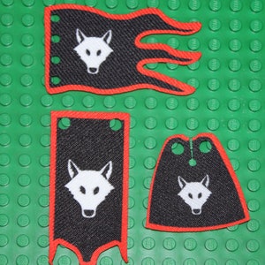Könnte beinhalten: Drei schwarze und rote Stoffbanner mit einem weißen Wolfskopfdesign. Die Banner haben einen gezackten Rand und sind aus einem strukturierten Stoff gefertigt.