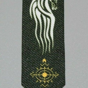Könnte beinhalten: Ein grünes Stoffbanner mit einem weißen Pferdekopfdesign und einem goldenen Kompasssymbol.
