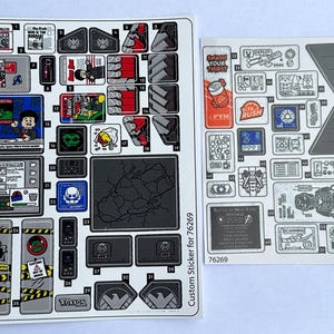 May include: A sheet of stickers for a LEGO set, featuring characters and objects from the Marvel Cinematic Universe. The stickers include a variety of designs, including the words "Smash Your Thirst", "Pym", "Vita Rush", and "Battle of New York".
