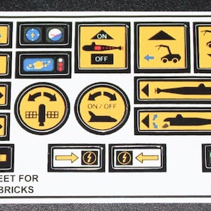 Può includere: Un foglio di adesivi con vari adesivi per pannello di controllo giallo, nero e rosso per un set Lego. Gli adesivi raffigurano un sottomarino, un'astronave, una gru e altri simboli. Il testo "CUSTOM STICKER SHEET FOR 8480 BY PASSIONFORBRICKS" è stampato nella parte inferiore del foglio.