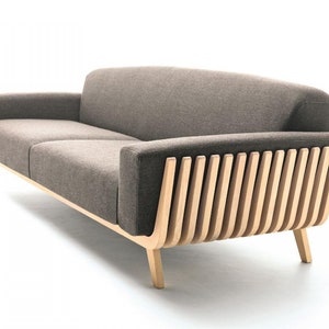 Peut inclure: Un canapé en tissu marron avec une structure en bois et un design à lattes unique au dos. Le canapé a un design moderne et est parfait pour un salon ou un bureau.