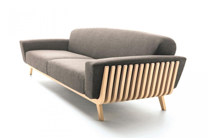 May include: A brown fabric sofa with a wooden frame and a unique slatted design on the back. The sofa has a modern design and is perfect for a living room or office.