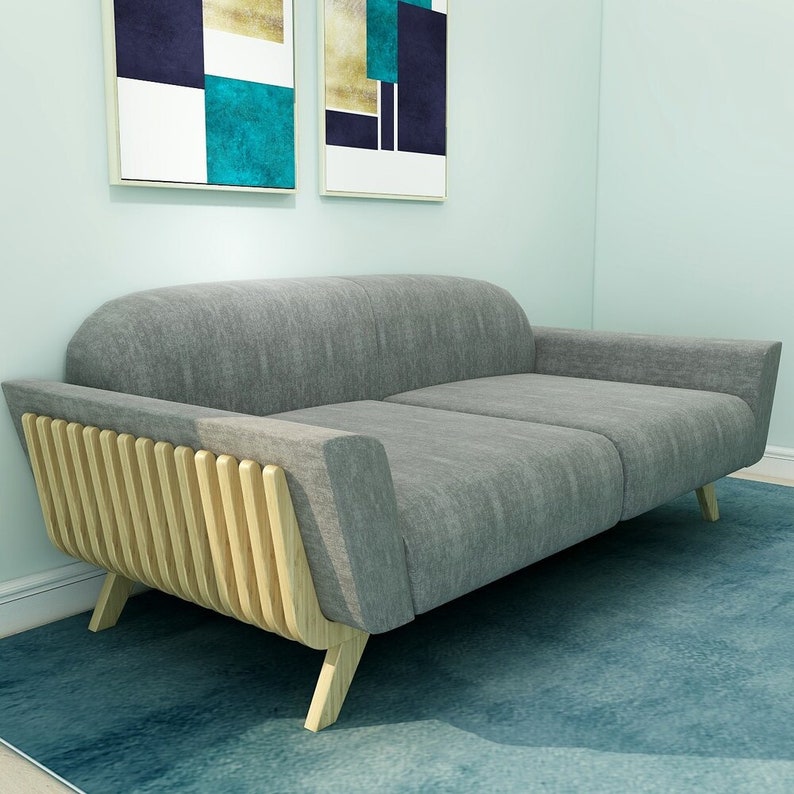 May include: A grey fabric sofa with a wooden frame. The sofa has a unique design with wooden slats on the back and arms. The sofa is sitting on a blue rug.