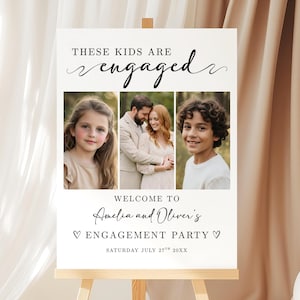 Op de afbeelding: Een wit bord op een houten ezel, dat een verlovingsfeest aankondigt. Het bord toont de tekst "THESE KIDS ARE engaged" en drie foto's. Er staat ook "WELCOME TO Amelia and Oliver's ENGAGEMENT PARTY" en de datum.