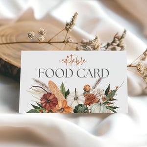 May include: A rectangular food card featuring the text editable FOOD CARD in orange and dark gray. The design includes a watercolor illustration of pumpkins, corn, and dried foliage in shades of orange, green, white, and brown at the bottom.