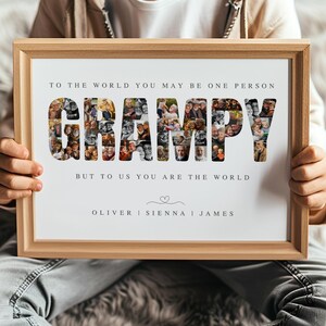 Peut inclure: Un cadre en bois contenant une impression avec le mot "GRAMPY" composé de plusieurs photos. Le texte au-dessus dit "POUR LE MONDE VOUS ÊTES PEUT-ÊTRE UNE PERSONNE" et en dessous "MAIS POUR NOUS VOUS ÊTES LE MONDE". Noms "OLIVER | SIENNA | JAMES" en bas.