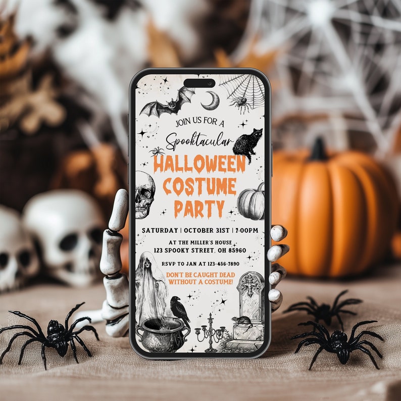 May include: A smartphone displays a Halloween Costume Party invitation. The invitation features a bat, spiderwebs, a black cat, a skull, and a pumpkin. The text reads "Spooktacular Halloween Costume Party" with date, time, and location details. Black plastic spiders and a skeleton hand are in the foreground.