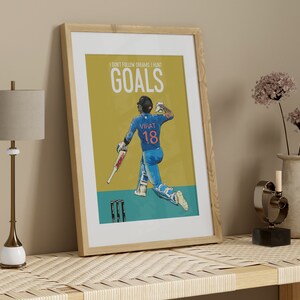 May include: A framed poster with a yellow background featuring a cricket player in a blue uniform with the text "I don't follow dreams, I hunt GOALS" and "VIRAT 18" on the poster.