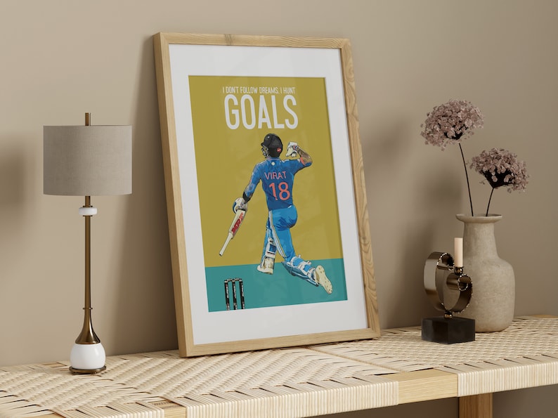May include: A framed poster with a yellow background featuring a cricket player in a blue uniform with the text "I don't follow dreams, I hunt GOALS" and "VIRAT 18" on the poster.