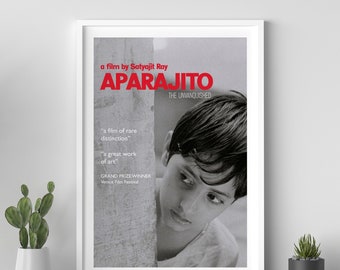 Puede incluir: Póster enmarcado de la película "Aparajito" de Satyajit Ray. El título es rojo, con una imagen en blanco y negro de un niño. El texto incluye "The Unvanquished" y citas sobre la película. Ganador del Gran Premio en el Festival de Cine de Venecia.