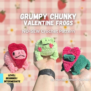 May include: Three handmade crochet frogs in pink, green, and red, with heart-shaped details. The image text says "GRUMPY CHUNKY VALENTINE FROGS" and "NO-SEW Crochet Pattern". The skill level is beginner to intermediate. The frogs are held in hands.