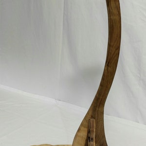 Pu&ograve; includere: Un supporto per chitarra in legno con un supporto per il collo curvo e una base con un'apertura per una tracolla per chitarra. Il supporto &egrave; in legno scuro con una finitura naturale.