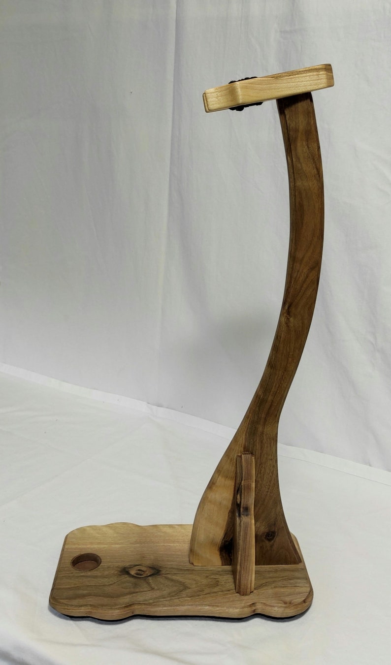 Pu&ograve; includere: Un supporto per chitarra in legno con un supporto per il collo curvo e una base con un'apertura per una tracolla per chitarra. Il supporto &egrave; in legno scuro con una finitura naturale.