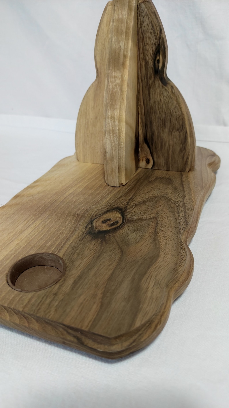 Pu&ograve; includere: Un vassoio di servizio in legno con una forma unica e libera. Il vassoio ha un piccolo ritaglio rotondo per una candela o altro piccolo oggetto. Il legno ha una finitura naturale e rustica.