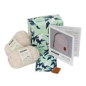 May include: A light green box and two skeins of yarn with the text "MOOMIN x NOVITA". The box has a Moomin character illustration and leaf design. A pattern and a leather tag are also included.