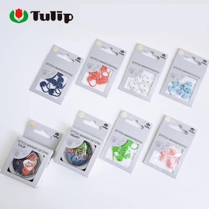 May include: Assortment of Tulip stitch markers in various colors, including blue, orange, white, and pink. The stitch markers are packaged in individual gray cardboard packs. The text "STITCH MARKERS(PIN)" is printed on the packaging.