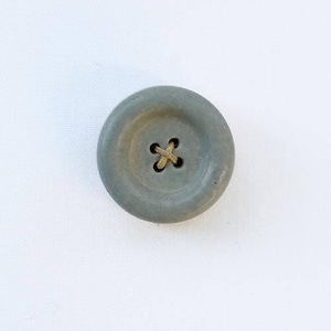a button with a cross on it sitting on a white surface